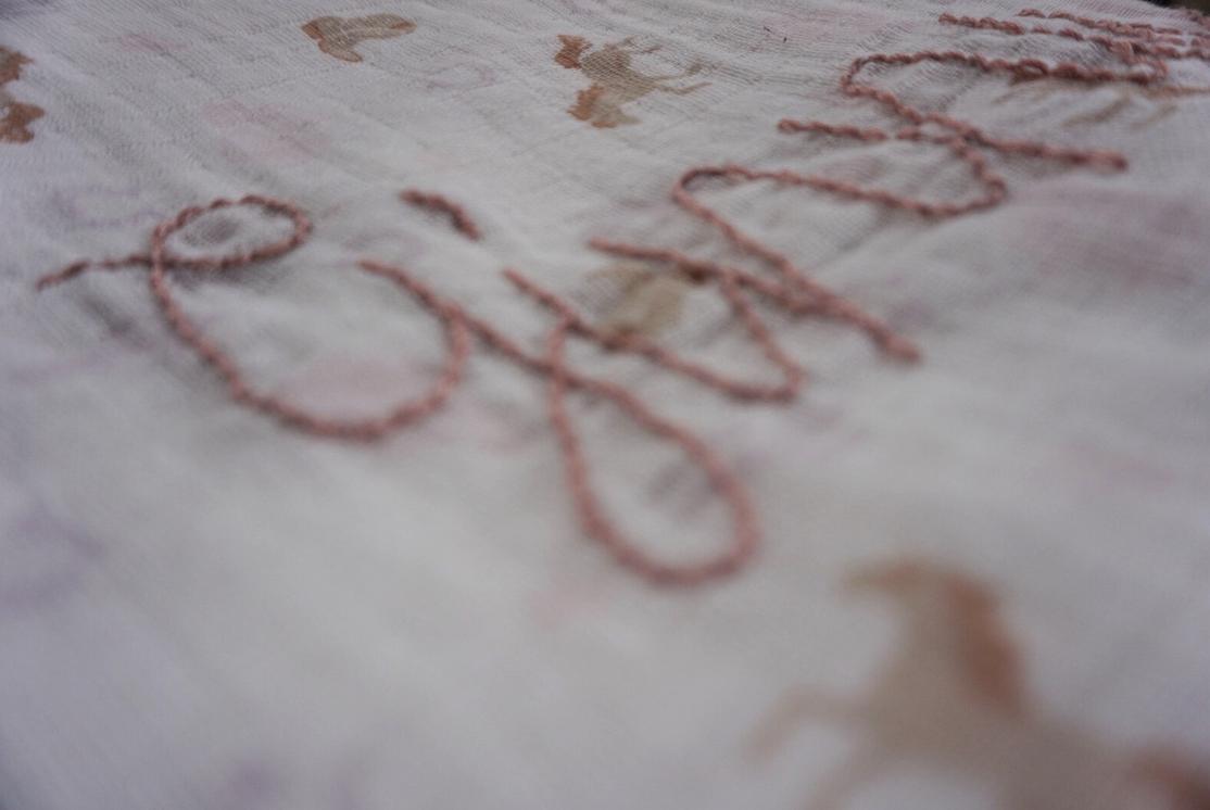 Embroidered text on fabric with floral patterns