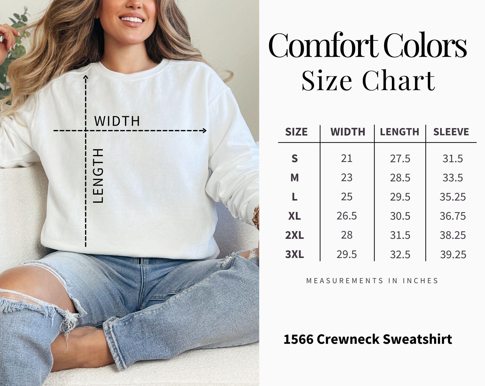Woman wearing a white sweatshirt with a size chart on the right side.