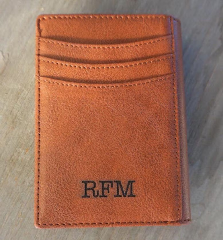 Brown leather wallet with 'RFM' initials on a textured surface